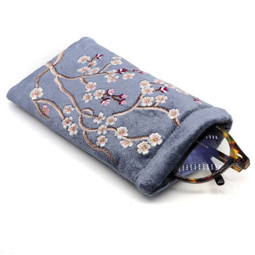 A dusky cobalt blue cotton velvet glasses case adorned with delicate pink sakura (cherry blossom) embroidery.