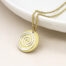 Faux gold-plated scratched disc necklace with a silver-plated spiral overlay, hanging from a delicate golden chain.