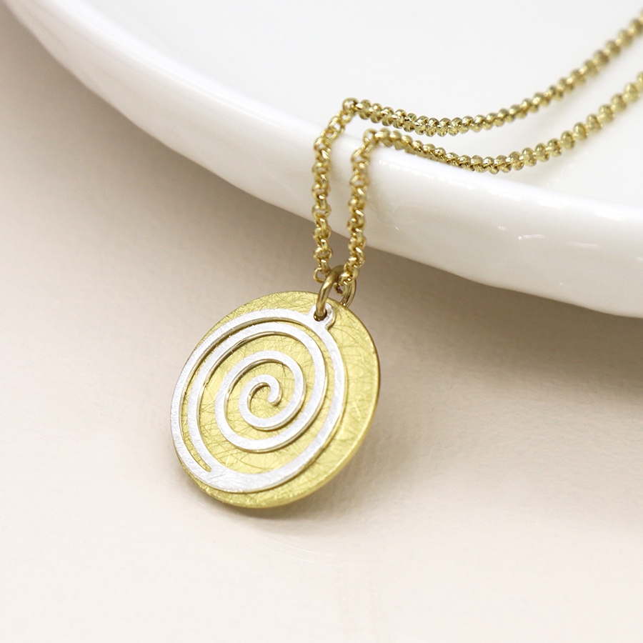 Faux gold-plated scratched disc necklace with a silver-plated spiral overlay, hanging from a delicate golden chain.