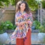 Eco-friendly organic cotton scarf featuring a hand-drawn floral print in soft pastel hues., stylishly finished with tassels. Ethically crafted for a stylish, sustainable accessory.