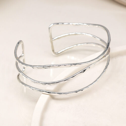 ​A silver-plated bangle comprising three slender, wave-like strands with a hammered texture, designed with an open back for adjustable wear.